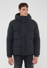 Giubbotto imbottito navy con cappuccio, dotato di zip frontale, due tasche sul petto e due tasche a toppa frontali. Design a trapunta texture.