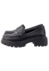 Zwarte, gewatteerde leren loafers met een dikke, gestructureerde zool. Heeft een gevlochten band over de bovenkant en een afgeronde teenvorm.