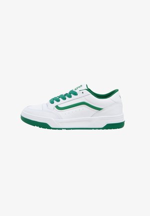Basket basse blanche avec des lacets verts, une doublure intérieure verte, une semelle verte et un détail de bande verte le long du côté.