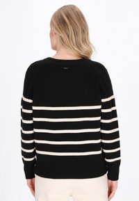 Maglione a righe nere e crema con orlo e polsini a costine, caratterizzato da un motivo a maglia testurizzato sulle spalle e sulla schiena.