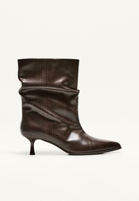 Botină din piele maro, cu un model texturat de piele de șarpe, design lejer, vârf ascuțit și toc subțire.