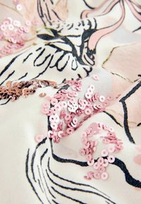 Țesătură florală cu detalii roz și negru, embellisată cu paiete roz dispersate pentru un plus de textură și interes vizual.