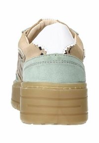 Beige suede sneaker with green accents and a white heel tab. Features a thick translucent sole with horizontal lines. Textured sides.