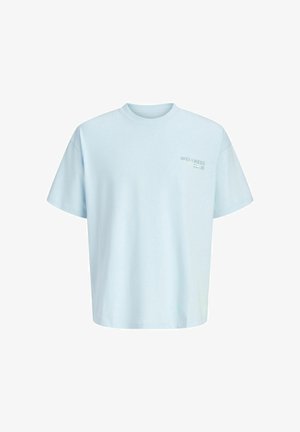 Lyseblå oversized T-skjorte med korte ermer og liten "WELLNESS CLUB" tekst trykt på venstre bryst.
