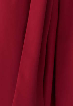 Rode stoffen draperie, gladde textuur, licht glanzende afwerking, met een strak uiterlijk. Kenmerkt zich door plooien die zachte lijnen en diepte creëren.