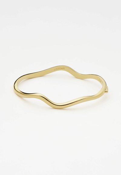 Bracciale in metallo color oro con un design ondulato e una superficie liscia. Inciso con "MISSOMA" all'interno. Non regolabile.