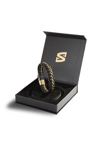 Lederarmband mit goldenen Akzenten, geflochtenes Design. Präsentiert in einer schwarzen Box mit gepolstertem Inneren und goldenem Logo auf dem Deckel.