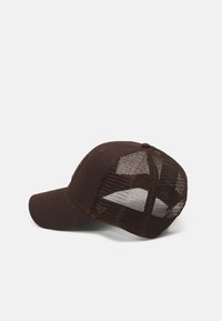 Brun hatt med solid front og nettingbakside. Buet skjerm, justerbar stropp bak, diskret logodesign på siden. Strukturt stoff.