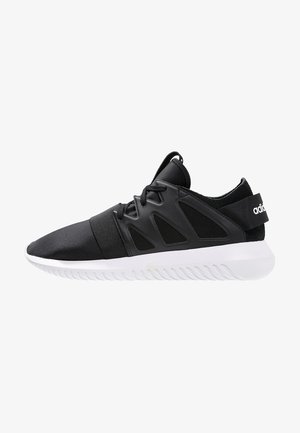Baskets Adidas noires avec semelle blanche, bande élastique au niveau des orteils, lacets sur l’avant et logo sur la languette du talon, montrées en profil latéral.