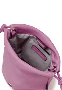 Small pink drawstring handbag with silver metal rings, gray inner lining, and an inner pocket with a label.