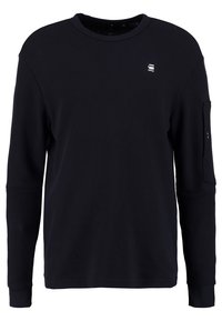 Schwarz langärmliges Crewneck-Shirt mit kleinem weißen G-Star RAW-Logo auf der Brust und einer geknöpften Tasche am linken Ärmel.