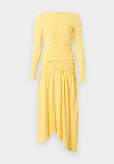 Robe midi jaune à manches longues avec corsage froncé et jupe asymétrique plissée, présentée sur fond blanc.