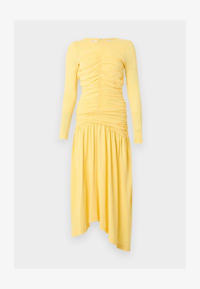 Robe midi jaune à manches longues avec corsage froncé et jupe asymétrique plissée, présentée sur fond blanc.