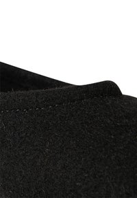 Černý filcový svršek boty s hladkým povrchem, zaobleným okrajem a viditelným šitím. Návrh neobsahuje žádné další kovové prvky nebo akcenty.