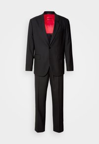 Czarny garnitur składający się z jedno rzędowej marynarki z klapami z wycięciem, spodni o prostych nogawkach oraz czerwonej podszewki wewnętrznej z etykietą marki.