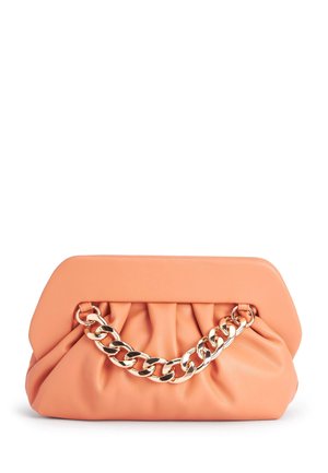 Pochette pêche douce avec une texture froncée et une anse chaîne dorée épaisse et remarquable à l’avant.