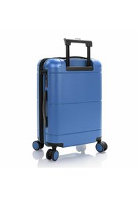 Valise rigide de couleur bleu vif, équipée d'une poignée noire rétractable, d'une fermeture éclair et de quatre roulettes accentuées de bleu pour une meilleure mobilité.