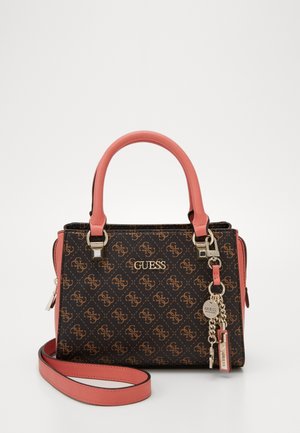 Mała torebka Guess z brązowym wzorzystym korpusem, różowymi uchwytami i paskiem, złotym logo oraz dołączonymi złotymi brelokami z zawieszkami.