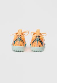 Zapatillas deportivas naranjas con una parte superior texturizada, decoradas con acentos azules, que cuentan con cordones y una suela de goma verde claro.