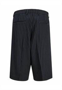 Shorts noirs à fines rayures, longueur genou, avec passants de ceinture et deux poches passepoilées à l'arrière, sur fond blanc.