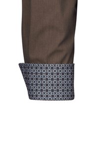 Braunes Stoffhemdmanschette mit einem blauen geometrischen Muster. Verfügt über eine kontrastierende hellblaue Innenverkleidung und eine glatte Textur.