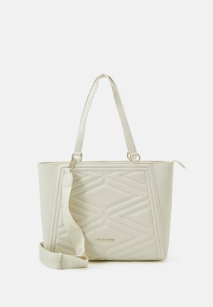 Sac fourre-tout beige clair avec un design matelassé géométrique, poignées doubles et bandoulière réglable. Présente un détail logo doré sur le devant.