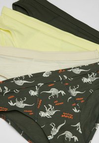 Quatre paires de sous-vêtements pour garçons en vert, jaune clair, crémeux et un vert avec des imprimés de squelettes de dinosaures et du texte, présentant des ceintures élastiques.
