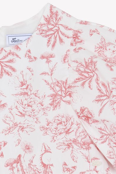 Blusa floral com fundo branco, estampada com flores e borboletas em cor-de-rosa coral. Tecido suave com uma textura lisa. Decote arredondado.