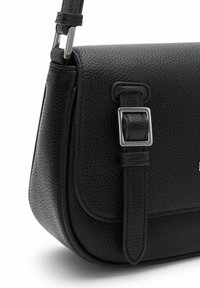 Bolso cruzado de piel negra con textura granulada, que presenta un acento de hebilla plateada, correa de hombro plana y forma estructurada.