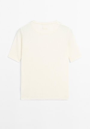 T-shirt en tricot blanc uni à manches courtes avec col rond, posé à plat sur un fond blanc, montrant le devant.