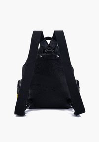 Zaino piccolo in pelle nera texture con ampie spalline in tessuto nero, rivetti argentati visibili e manico superiore, mostrato dal retro.