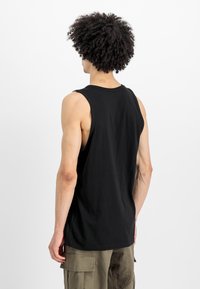 Μαύρο αμάνικο φανελάκι κατασκευασμένο από βαμβάκι, με στρογγυλή λαιμόκοψη και χαλαρή εφαρμογή, εμφανίζεται από πίσω με ορατές λεπτομέρειες στους ώμους και τα χέρια.