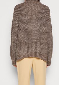 Maglione marrone lavorato a maglia con una vestibilità ampia, polsini e orlo a coste. Presenta un motivo testurizzato e un design con colletto alto.