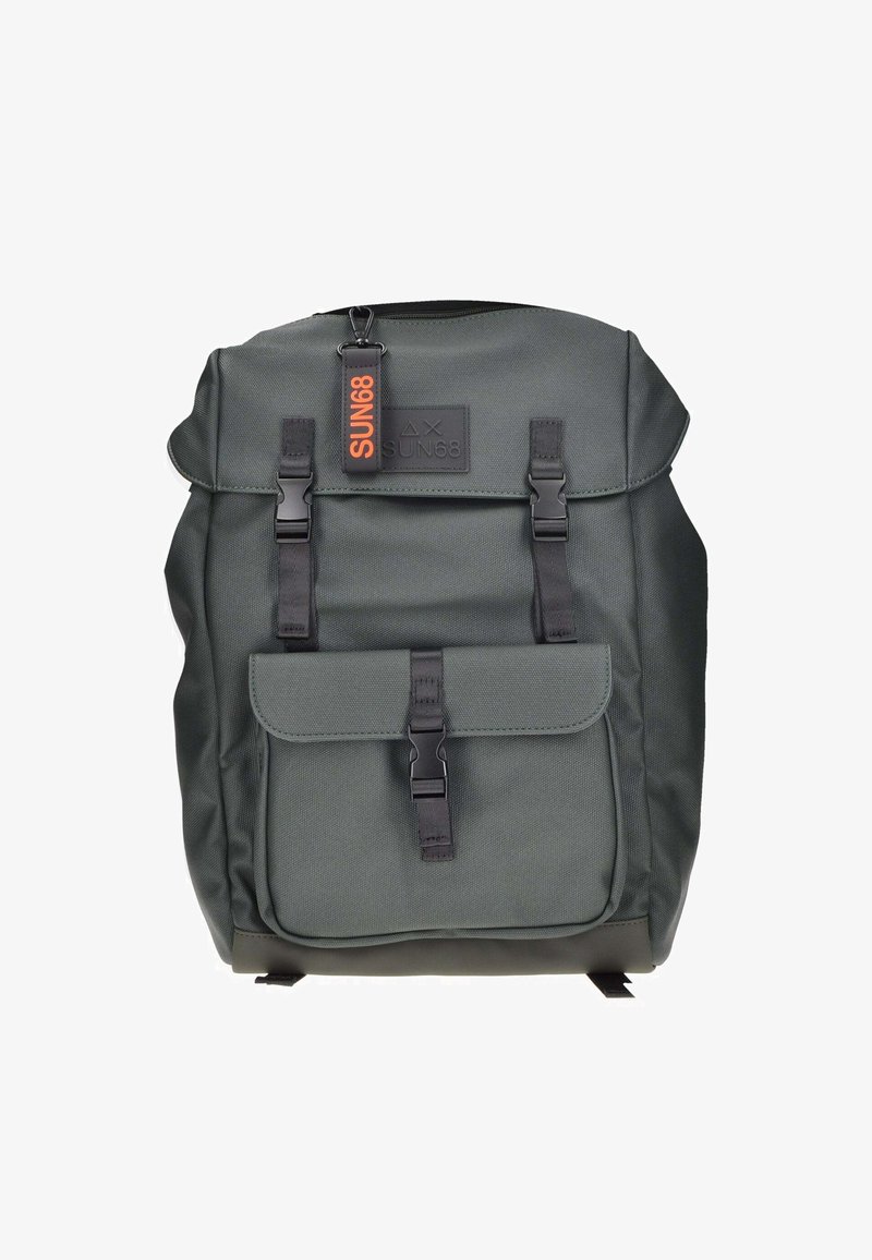 Mochila de color verde oscuro con una tela texturizada, que presenta una solapa superior, un bolsillo frontal, correas ajustables y una etiqueta de marca en color naranja.
