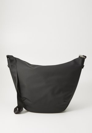 Schwarze Umhängetasche mit geschwungener Form, aus glattem Material, ausgestattet mit einem einzelnen Tragegurt und einem Reißverschlussverschluss oben.