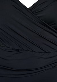 Maillot de bain noir en tissu lisse et extensible avec des détails froncés et un design à col en V, présentant une texture et des contours subtils.