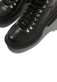 Zwarte leren wandelschoenen met metalen oogjes en zwarte veters. Heeft een structuurzool en een ronde neus, ontworpen voor duurzaamheid en ondersteuning.