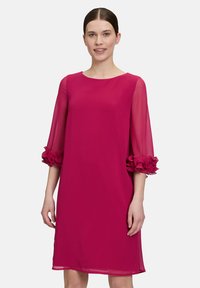 Fuchsia Kleid aus leichtem Stoff mit dreivierteltransparenten Ärmeln, die an den Bündchen gefaltete Rüschen aufweisen; runder Ausschnitt und A-Linien-Schnitt.