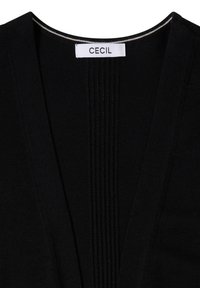 Vêtement en maille noire avec un détail côtelé vertical au centre et une étiquette blanche portant l'inscription "CECIL" au niveau de l'encolure.