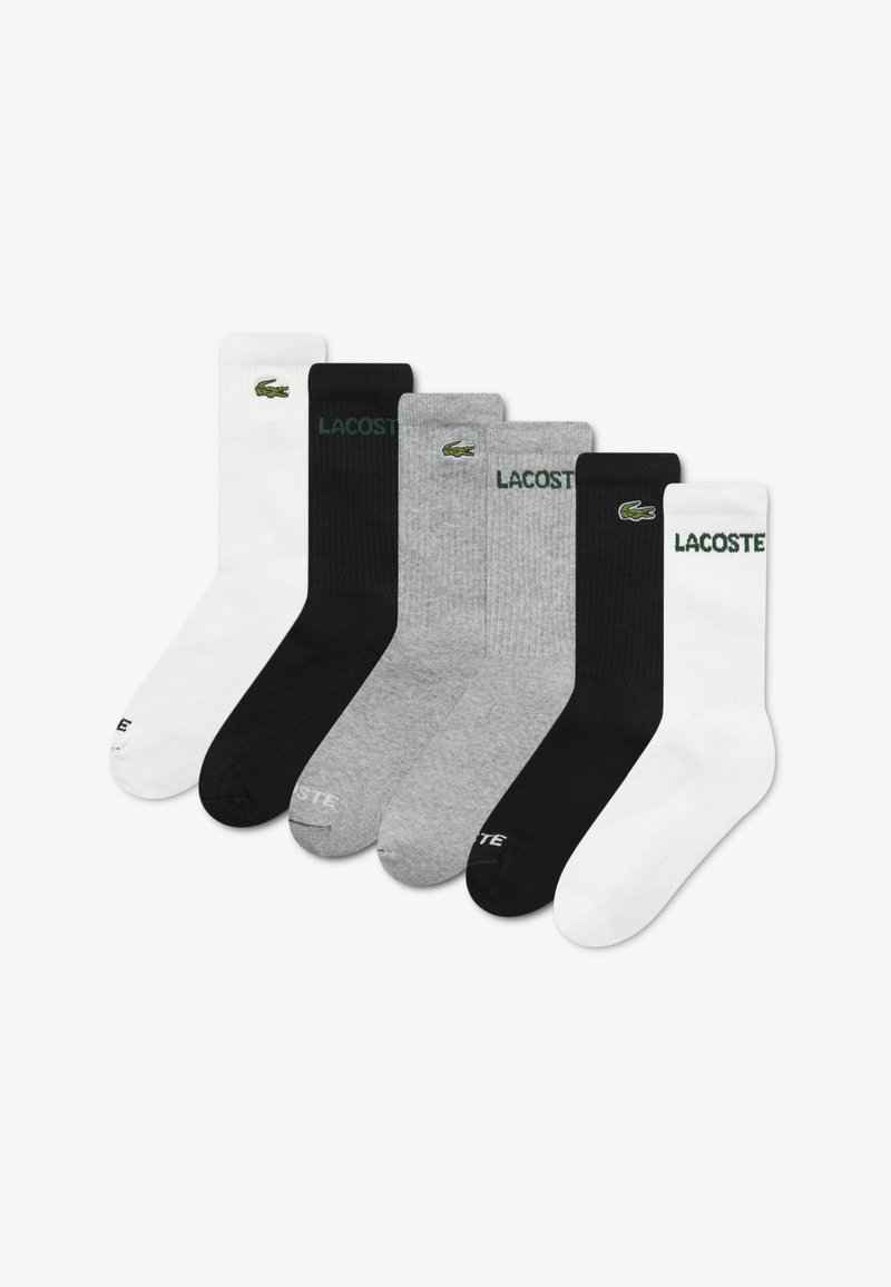 Πακέτο έξι κάλτσες σε διάφορα χρώματα: λευκό, μαύρο, γκρι. Κατασκευασμένες από βαμβάκι με ριμπ ύφανση. Διαθέτουν κεντημένο λογότυπο Lacoste σε κάθε μία.