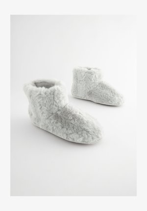 Grijze pantoffels van nepbont met een zachte, pluizige textuur, enkellaarshoogte en een afgeronde teen. De zolen zijn glad en vlak.