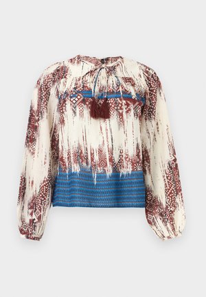 Long-sleeve blouse with abstract red and white patterns, blue horizontal stripes at hem, and brown tassel ties at neckline.