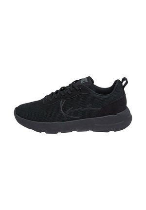 Schwarze Sportschuhe mit einem Netzobermaterial, abgerundetem Zehenbereich, flacher Sohle und minimalistischem Design mit Schnürsystem und Zugschlaufe an der Ferse.