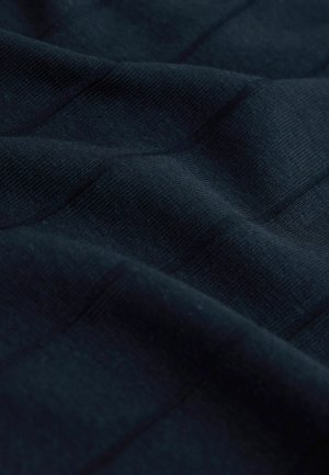 Mörkblått texturerat tyg med ett subtilt ribbat mönster som visar mjuka, släta fibrer och mjuka veck.