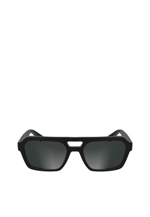 Lunettes de soleil rectangulaires noires avec une monture épaisse et une petite découpe triangulaire au-dessus du pont du nez, verres teintés foncés et branches droites.