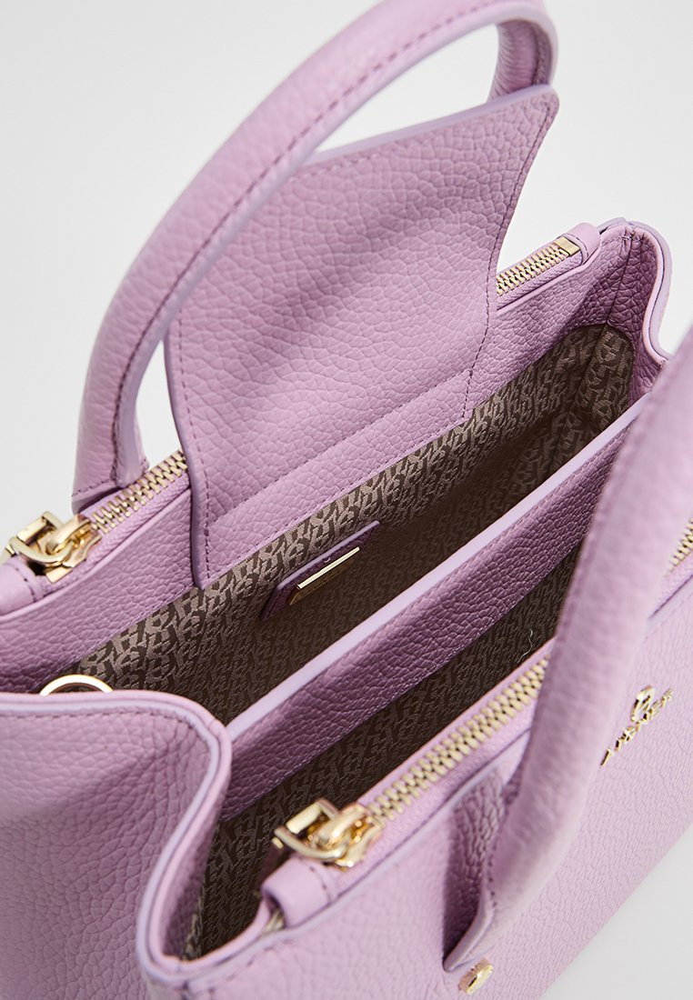 Lila Handtasche mit einer strukturierten Lederaußenseite, goldenen Beschlägen und einem gemusterten Stofffutter. Verfügt über einen Reißverschluss und zwei Tragegriffe.
