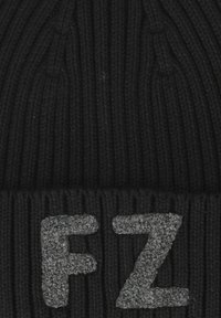 Svart stickad mössa med ett texturerat ribbat mönster. Har grå, plyschig bokstäver "FZ" på den vikta kanten för extra detalj.