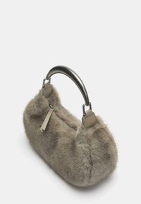 Handtasche aus Kunstfell in Beige mit abgerundeter Form, einem glatten grauen Metallgriff und Lederakzenten. Weiche Textur mit flauschigen Kanten.