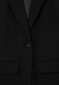 Schwarzer Blazer mit Knopfverschluss, mit Reverskragen und zwei vorderen Taschen. Der Stoff hat eine glatte Textur, ist einfarbig und hat keine Muster.