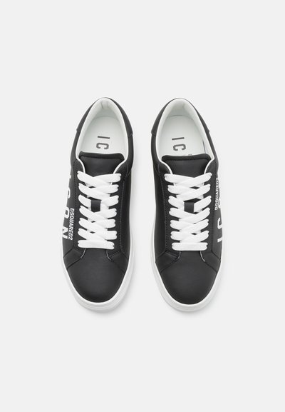Sneakers in pelle nera con lacci bianchi e logo laterale, caratterizzate da una punta rotonda e una suola in gomma testurizzata. Design semplice e minimalista.